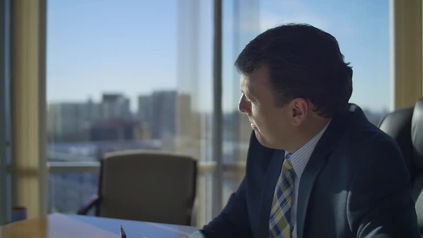 Business man sits at a desk in deep thought