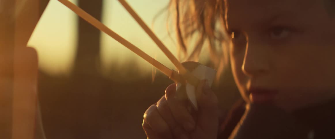 A child aiming with a slingshot