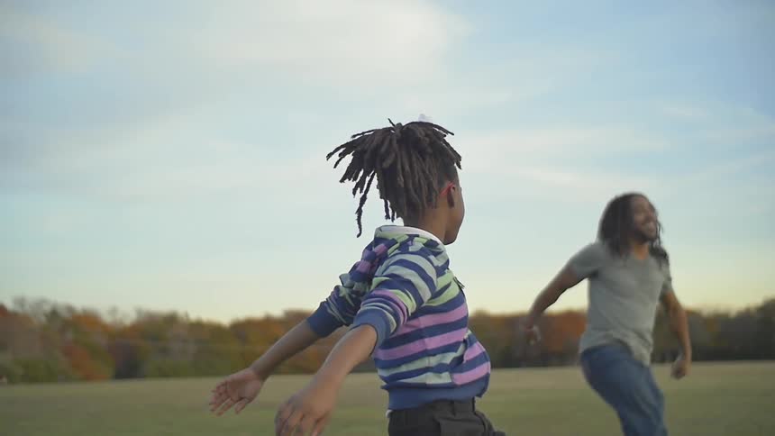Man and child playing in a field