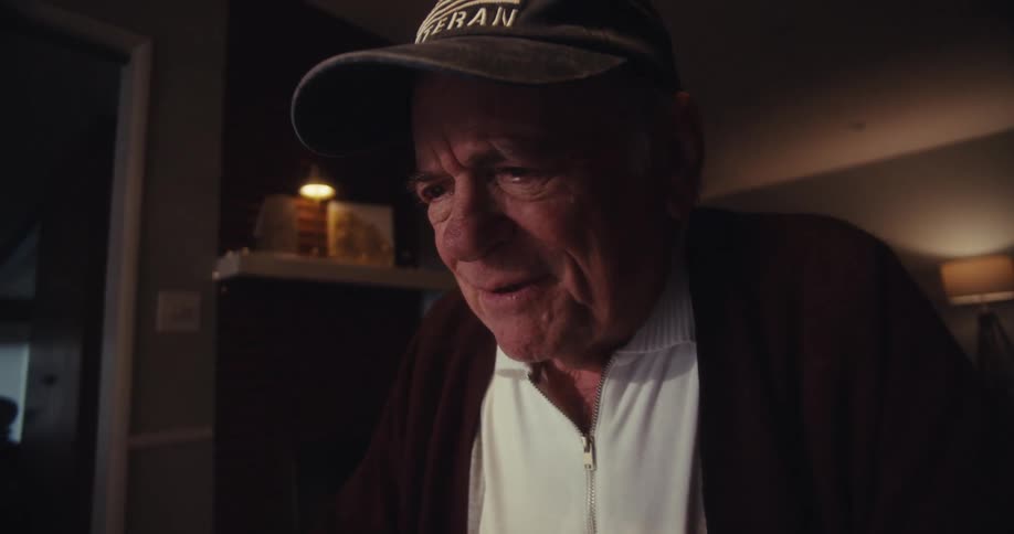 A man is smiling and talking at home