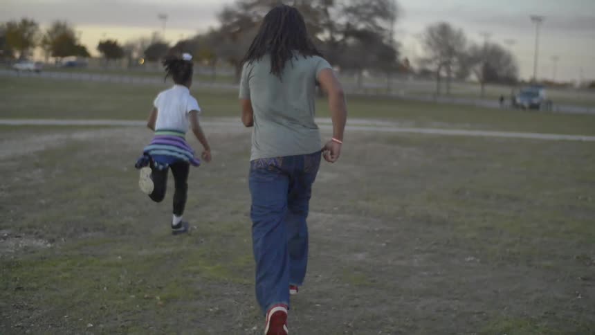 A man and girl running through a field