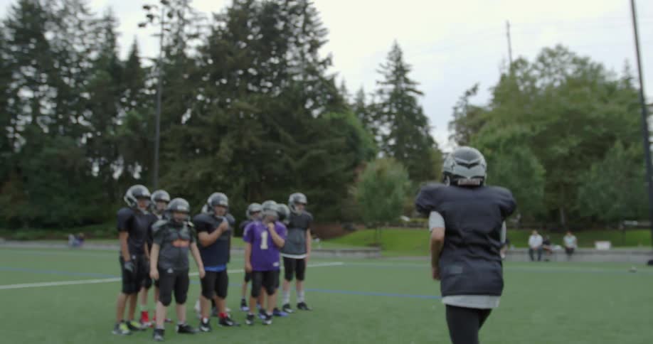 A football player runs to his other players on a field