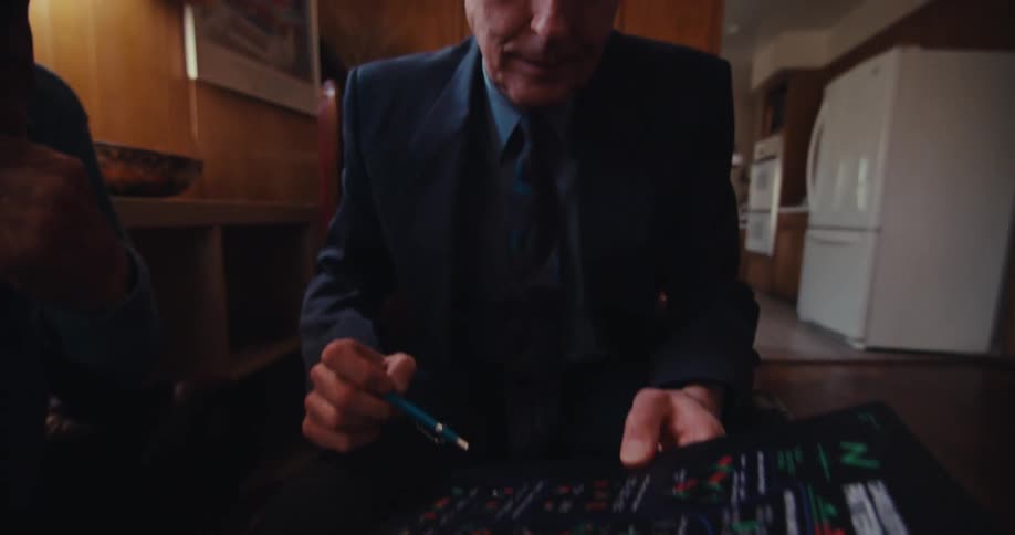 A man is talking and pointing at a brochure with his pen