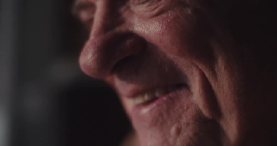 A closeup of an elderly man his facial expression thoughtful and content