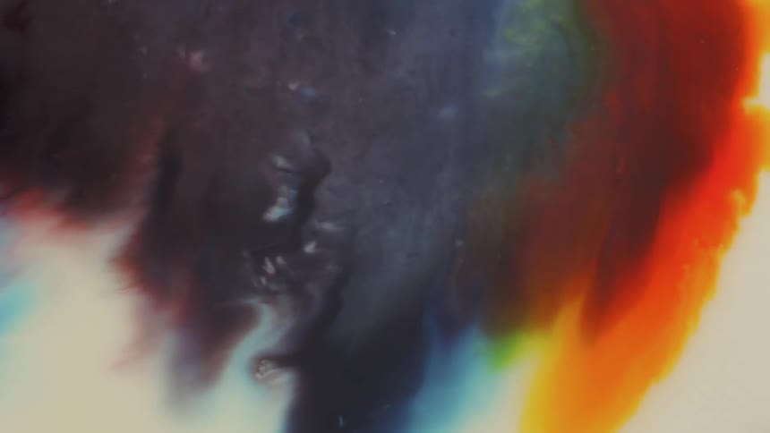 Colored liquid pours and mixes together