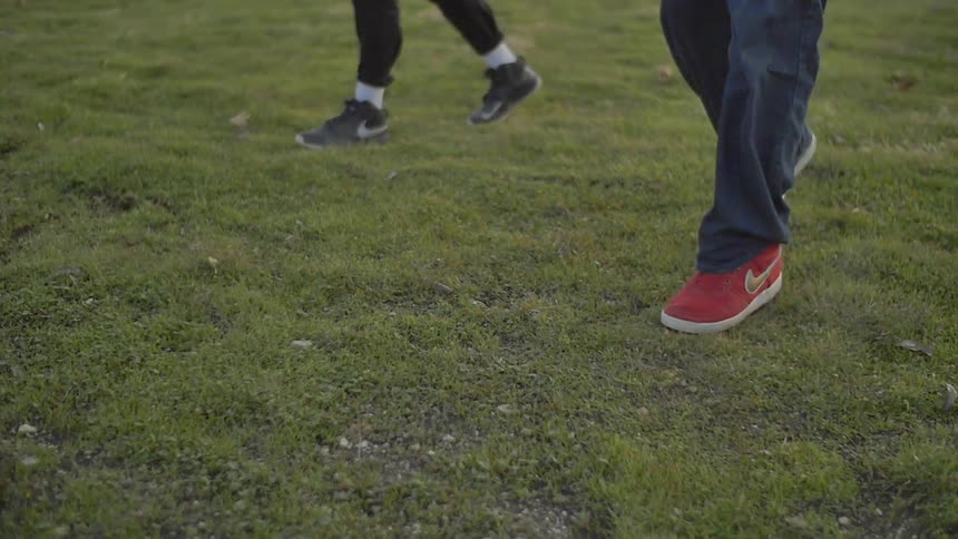 Two people are dancing on grass during the day