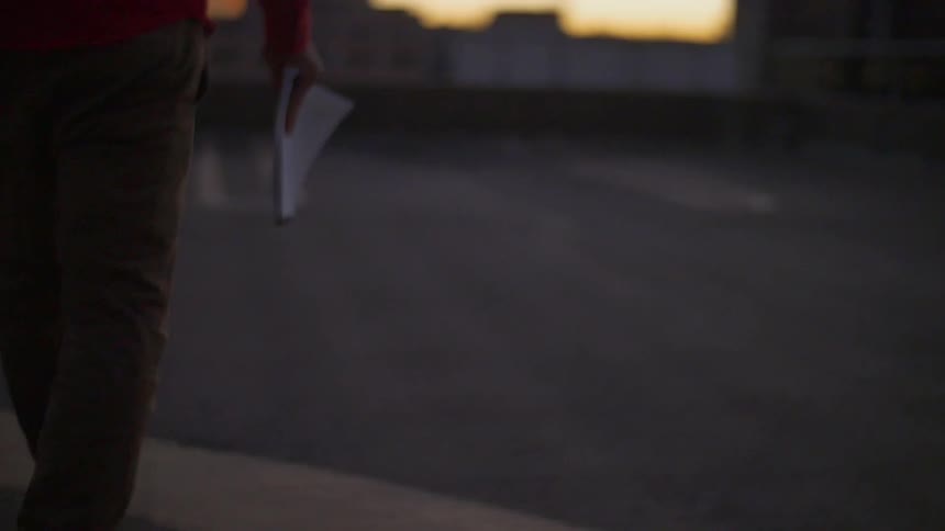 A person carrying a notebook walking on the road