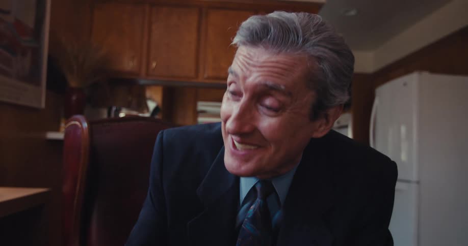 Elderly man shakes hands with an older businessman during a discussion at home