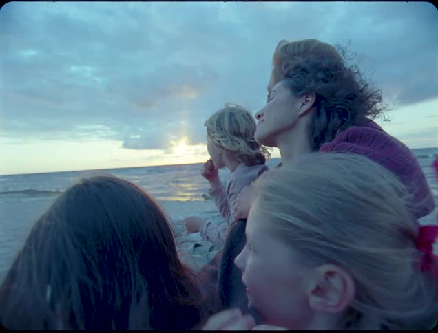 Family enjoys the beach near sunrise on a windy day