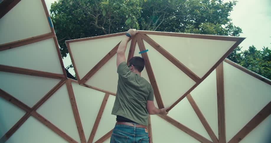 A man is building a partition in the yard