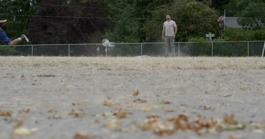 Group of boys play football in an empty lot,