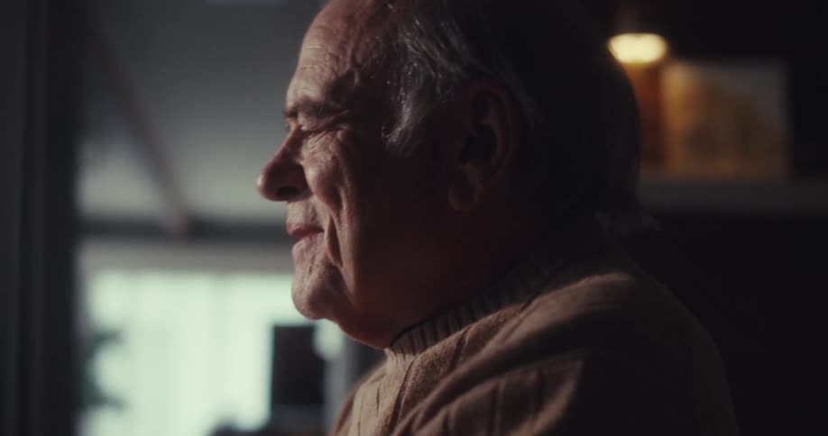 A man leans back laughing at home