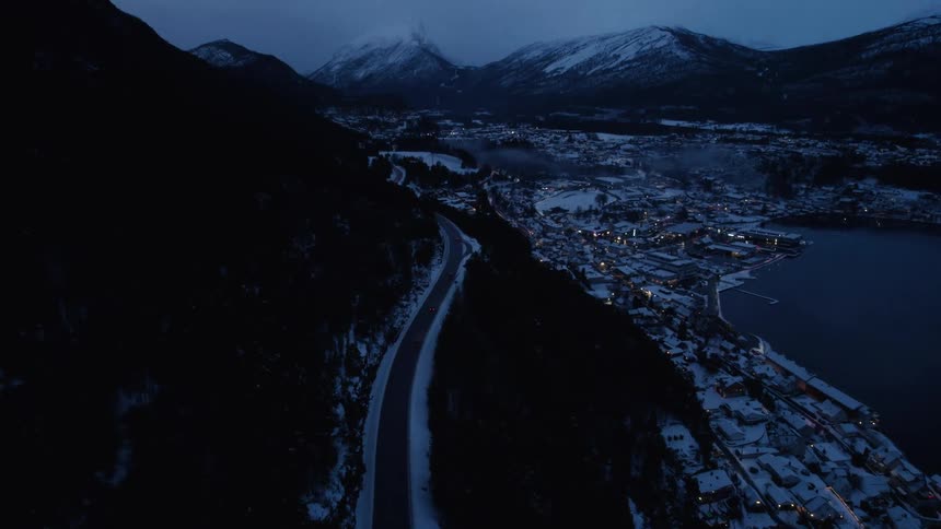 A small town is around the lake near the mountains