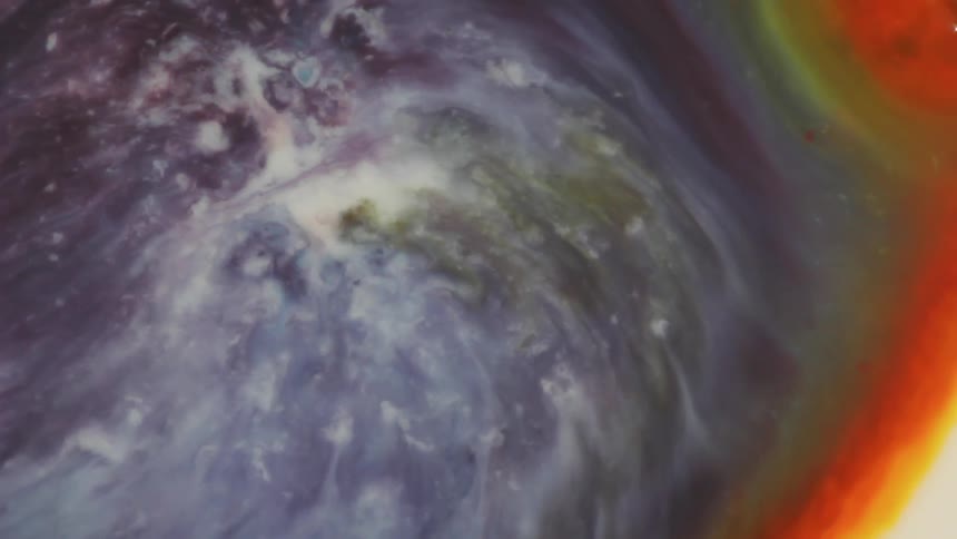 Colored liquid pours and mixes together