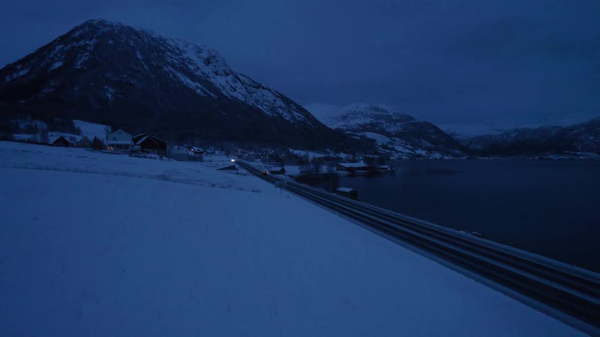 The car is driving towards the small town by the mountain