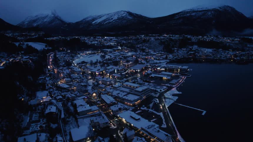Snowcovered city by the sea and surrounded by mountains