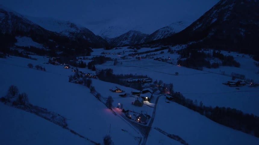 Scattered houses in a snowy mountain village at night
