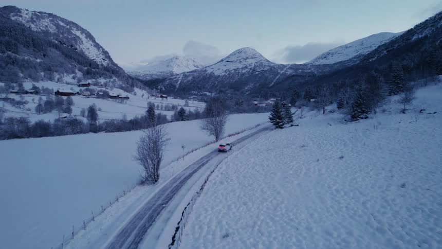 A car driving on a road in a completely elevated environment with pine trees and mountains in the background