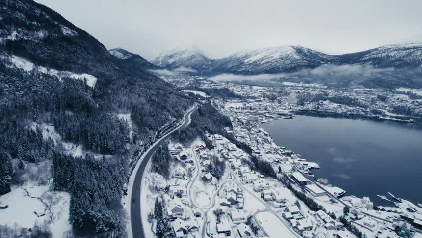 Aerial view of a coastal village at the foothills of a mountain range