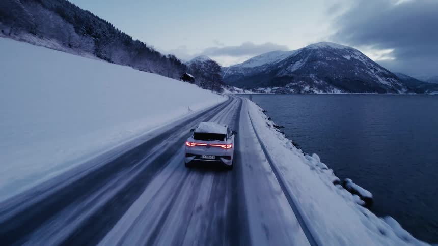 An suv driving on the freeway by the ocean on a winter morning