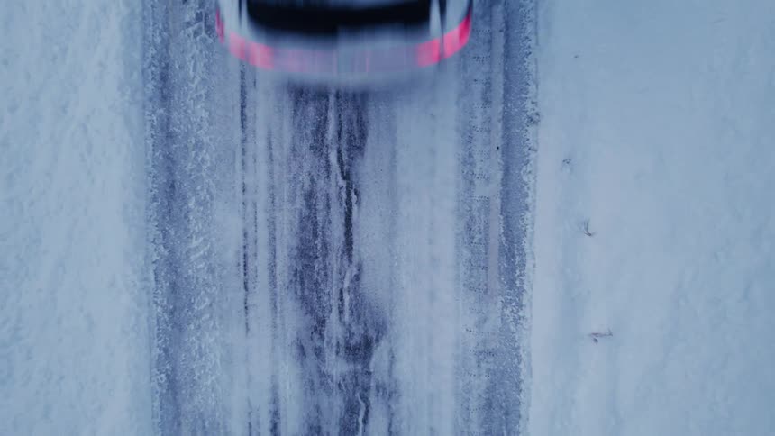 View from above of an suv driving on the snow covered road