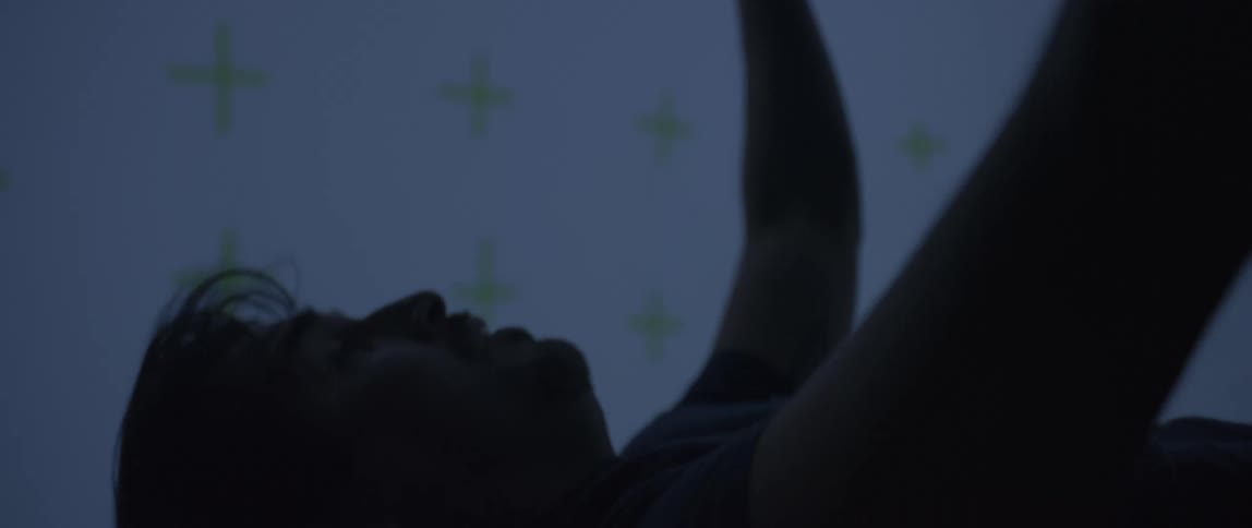 Man floating in a wind tunnel with yellow crosses on the walls