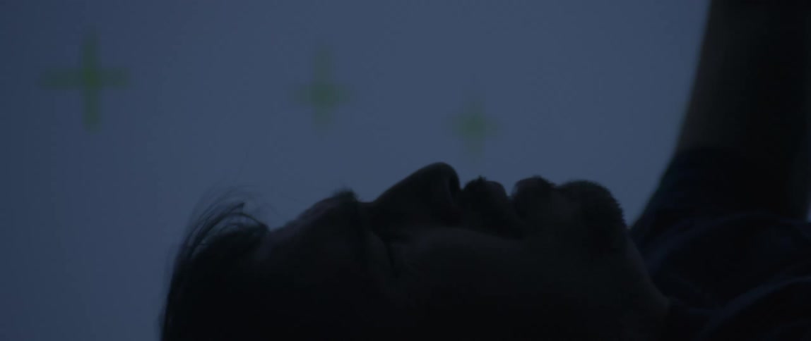 Close up of a man with hair flowing hands raised as if plummeting from great heights but he is actually in a dimly lit motion capture studio