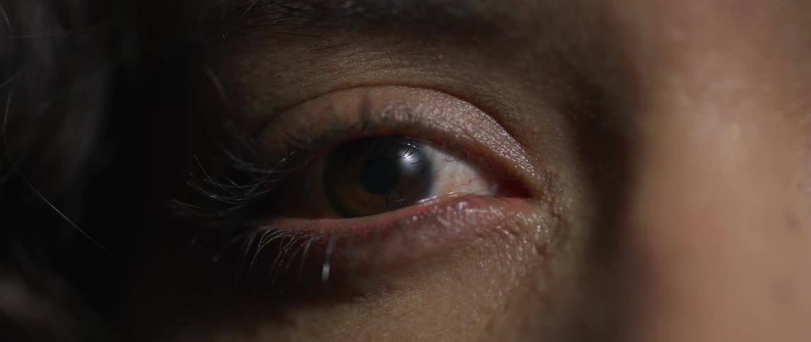 An extreme closeup of a human eye capturing intimate skin texture and emotional detail