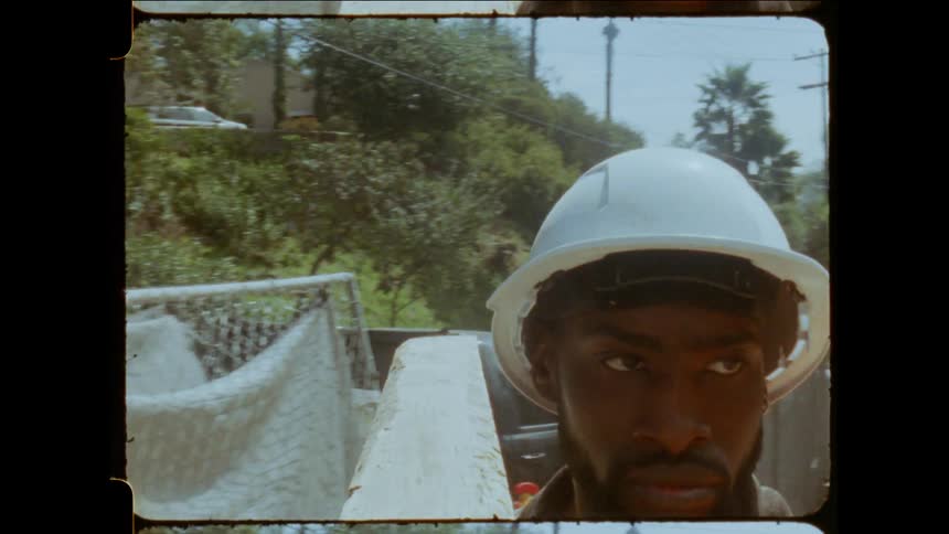 A construction worker is carrying a wooden board