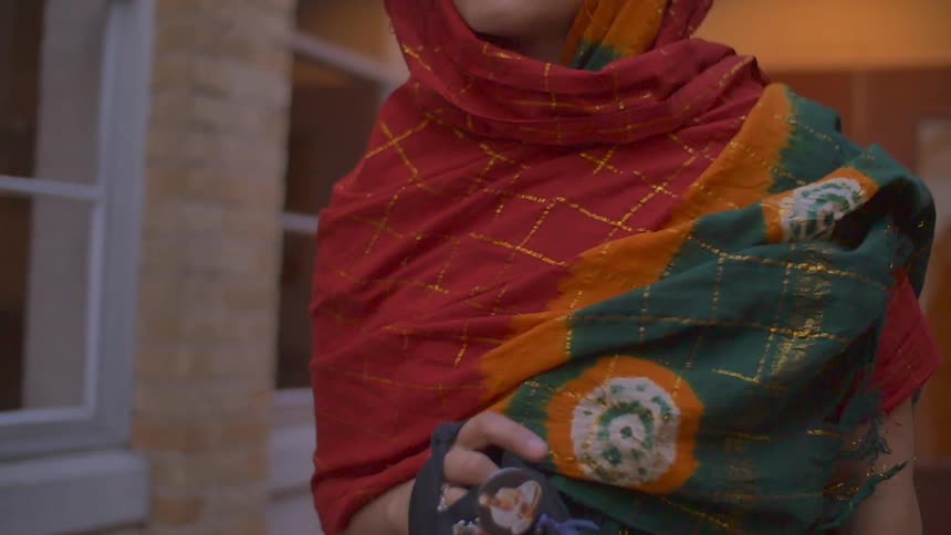 A woman wearing a sari is walking outside