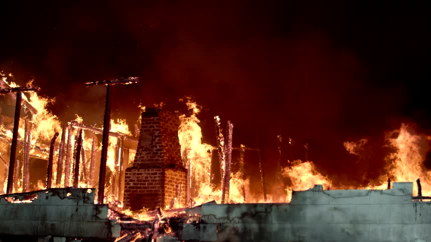 Heavy smoke and flames rise from the burning home