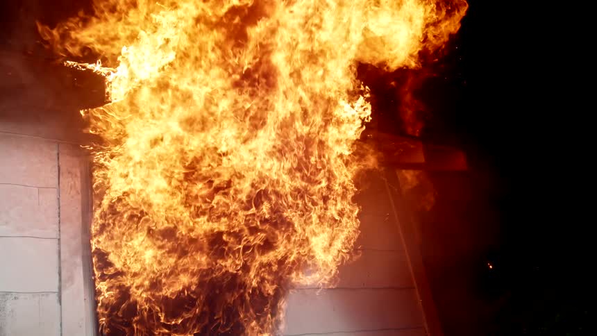 Flames are shooting out the burning homes window