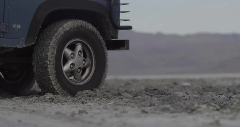Vehicle tires roll and slide through dirt