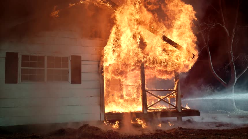 Water is being sprayed on the out of control fire in the home
