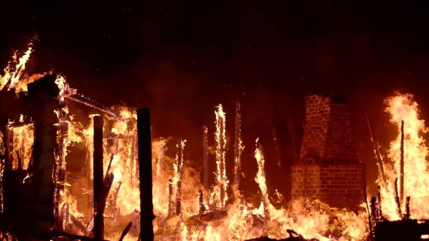 Smoke and fire rise from the burning home