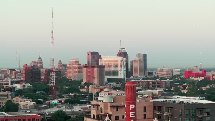 Wide shot of the san antonio skyline at dusk with standout architecture and a soft evening sky