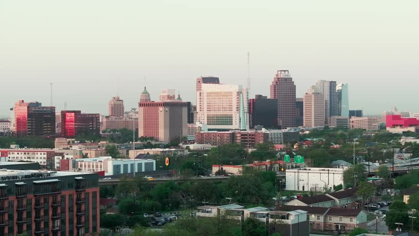 An aerial view of san antonio texas reveals a cityscape featuring a blend of lowrise and highrise buildings beneath a hazy sky