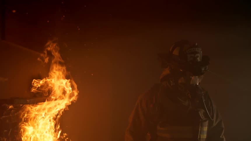 A firefighter runs through a fire