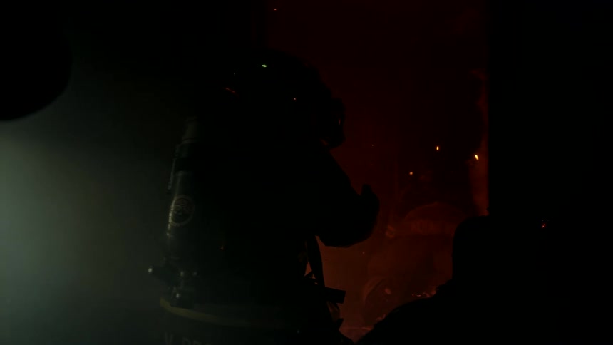 Two firefighters entering a burning house