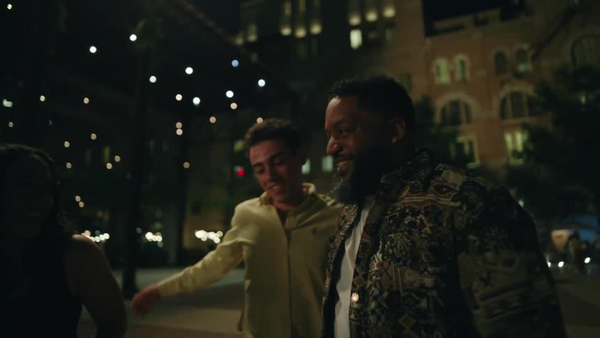 Three friends walking down the street talking and smiling