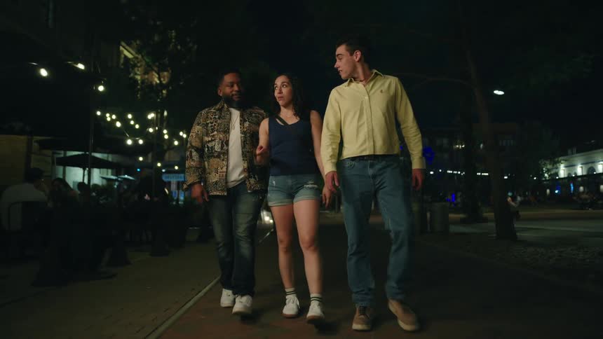 Friends walk and talk in the city at night