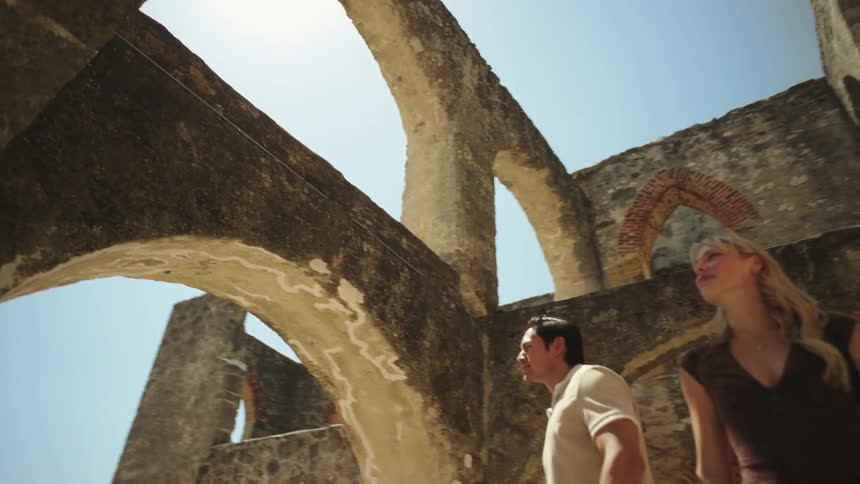 A couple are touring ruins on a sunny day