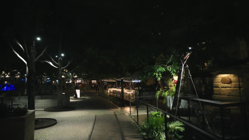 A resorts outdoor area is filled with lights at night illuminating the beauty of the walkway