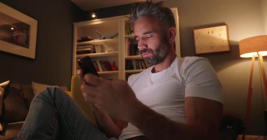 A man is on his phone in a living room