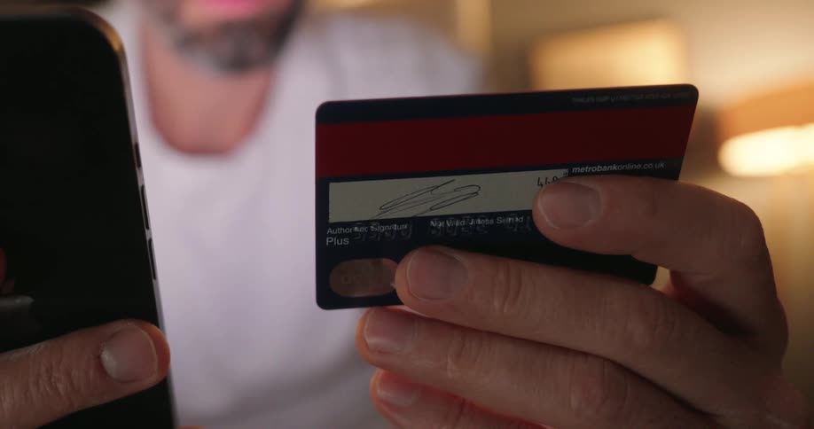 A man types his credit card number into his phone
