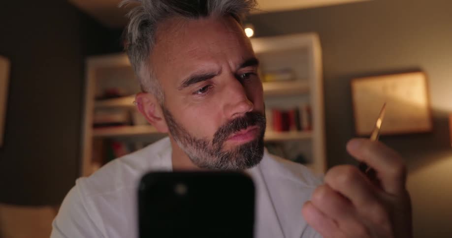 Older man shops online using his smartphone and credit card