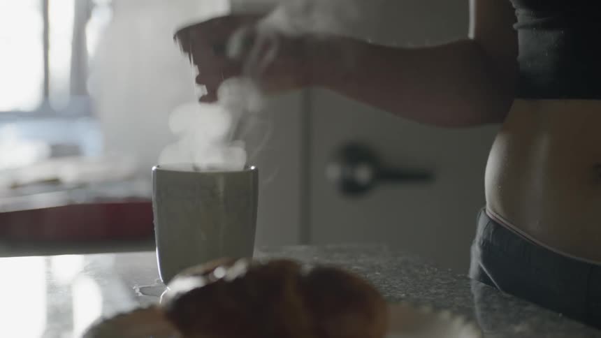 A woman pours boiling water into a cup