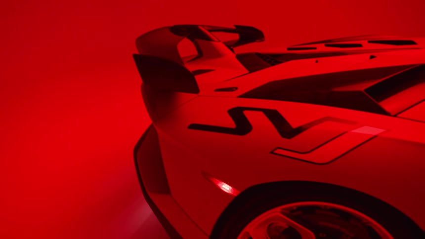 Red colored light illuminates a parked sports car