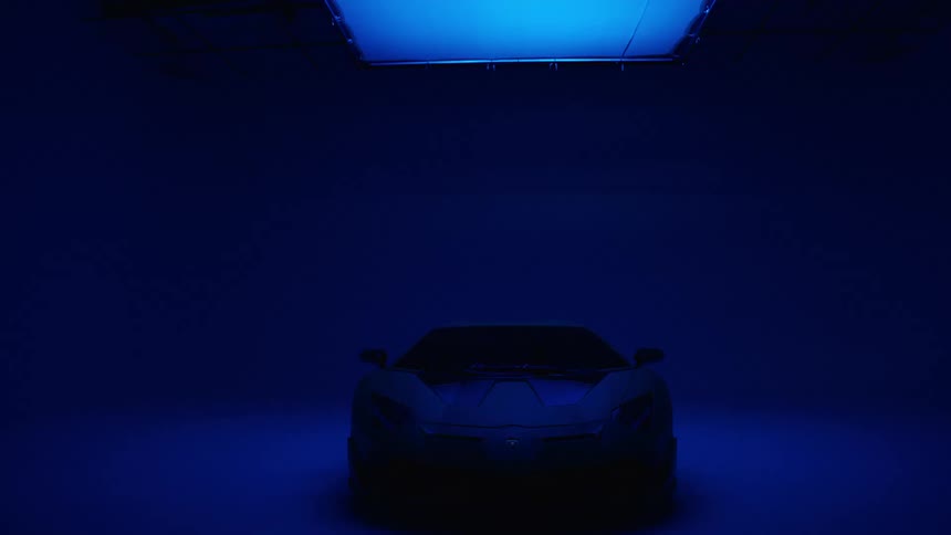 The car is parked on the dark stage