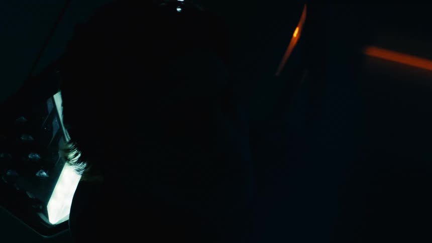 A man leaning against a sports car in a car garage